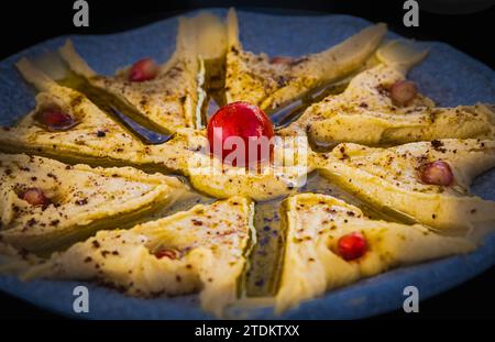 Schüssel Hummus. Klassischer Hummus mit Petersilie auf einem Teller. Traditioneller Hummus-Salat. Nahöstliche oder arabische Küche. Gerichte mit Kichererbsen, eine Vegetaria Stockfoto