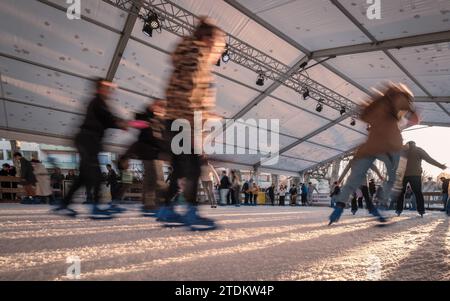 Sarlat-la-Canéda, Nouvelle-Aquitaine, Frankreich - 16. Dezember 2023: Eisläufer auf der Eisbahn auf dem Weihnachtsmarkt Sarlat-la-Canéda in der Dordogne Re Stockfoto