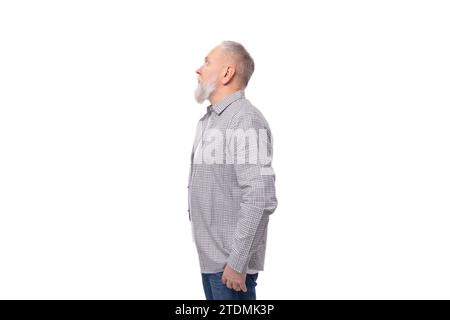 Ein süßer, kluger Großvater mit weißem Bart und Schnurrbart in einem gestreiften Hemd steht im Profil Stockfoto
