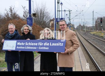 19. Dezember 2023, Brandenburg, Lübbenau: Alexander Kaczmarek (l-r), Gruppenbeauftragter der Deutschen Bahn für Brandenburg, Susanne Henckel, Staatssekretärin im Bundesverkehrsministerium, Ute Bonde, Geschäftsführer des VBB, und Rainer Genilke (CDU), brandenburgischer Minister für Infrastruktur und Raumordnung, stehen auf dem Bahnsteig des Bahnhofs Lübbenau während einer Presseveranstaltung zum Ausbau der Eisenbahnverbindung zwischen Lübbenau und Cottbus und halten ein Schild mit der Aufschrift „mehr Schiene für Lausitzer - Lübbenau - Cottbus-Erweiterung“. Foto: Soeren Stache/dpa Stockfoto