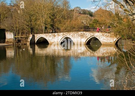 Wide Bridge in Bradford auf Avon Wiltshire England an einem sonnigen Wintertag im Dezember, an dem fünf Menschen den Fluss Avon überqueren Stockfoto