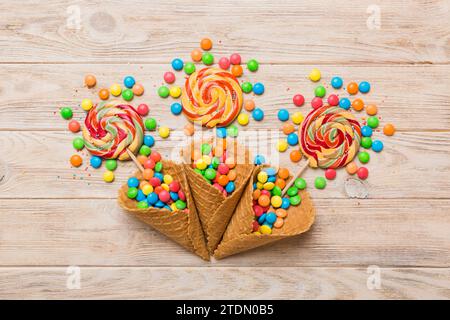 Waffelkonus voller traditioneller Süßigkeiten, die auf farbigen Hintergrund fallen, mit Platz für Kopien. Frohes Weihnachtsangebot. Stockfoto