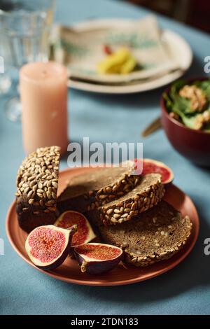 Nahaufnahme von geschnittenem Vollkornbrot und Feige auf Teller auf Tisch Stockfoto