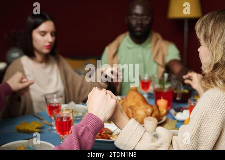 Nahaufnahme der Hände von kaukasiern, die zusammen Gnade sagen, sitzen am Festtisch des Danksagens Stockfoto