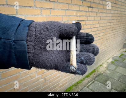 Rotterdam, Niederlande - 5. Dezember 2023: Ein Mann hält einen brennenden Marihuana-Joint in der Hand *** ein Mann hält einen brennenden Marihuana-Joint in der Hand Stockfoto