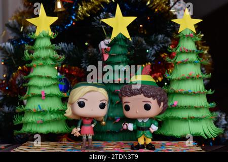 Funko Pop Actionfiguren von Jovie und Buddy aus dem Familienkomödie Elf. Weihnachtsbäume aus handgefertigtem Papier, Ornamente, Konfetti, Girlande, festliche Einrichtung. Stockfoto
