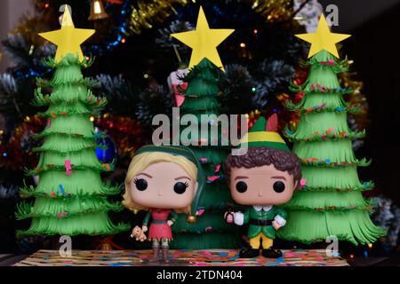 Funko Pop Actionfiguren von Jovie und Buddy aus dem Familienkomödie Elf. Weihnachtsbäume aus handgefertigtem Papier, Ornamente, Konfetti, Girlande, festliche Einrichtung. Stockfoto