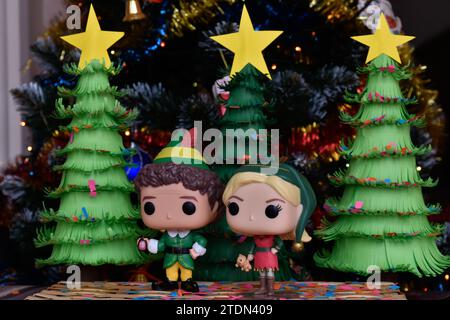 Funko Pop Actionfiguren von Buddy und Jovie aus dem Familienkomödie Elf. Weihnachtsbäume aus handgefertigtem Papier, Ornamente, Konfetti, Girlande, festliche Einrichtung. Stockfoto