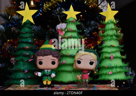 Funko Pop Actionfiguren von Buddy und Jovie aus dem Familienkomödie Elf. Weihnachtsbäume aus handgefertigtem Papier, Ornamente, Konfetti, Girlande, festliche Einrichtung. Stockfoto