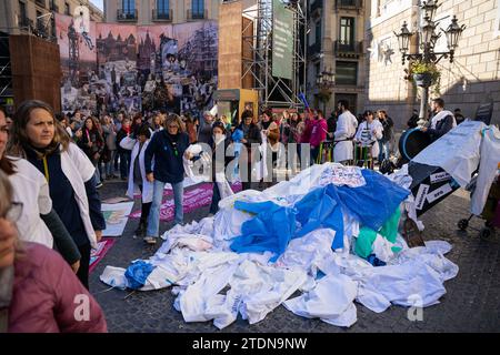 Barcelona, Barcelona, Spanien. Dezember 2023. Katalanische Gesundheitsexperten, die streiken, legen ihre Kleider auf einem Pappgrab ab, das den Tod des katalanischen Gesundheitssystems an der Tür des Palau de la Generalitat symbolisiert. Berufstätige fordern Verbesserungen der Arbeitsbedingungen. (Kreditbild: © Marc Asensio Clupes/ZUMA Press Wire) NUR REDAKTIONELLE VERWENDUNG! Nicht für kommerzielle ZWECKE! Quelle: ZUMA Press, Inc./Alamy Live News Stockfoto