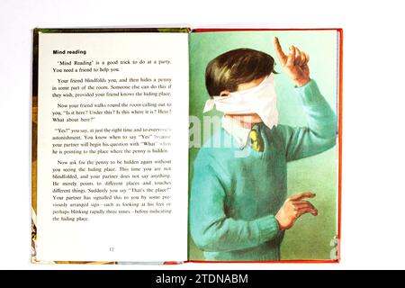 Illustration eines Jungen in Augenbinde Vintage 1960er Jahre Marienkäfer Buch Tricks und Magie isoliert auf weißem Studio Hintergrund Stockfoto