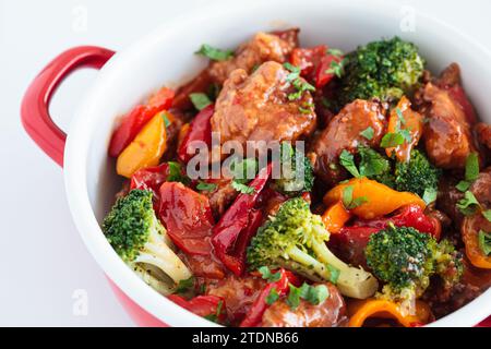 Gedünstetes Hähnchenfilet mit Gemüse in einer Pfanne, weißer Hintergrund, Nahaufnahme. Stockfoto