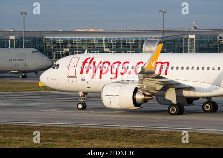 Pegasus Airlines Airbus A320 NEO Roller nach der Landung auf dem Flughafen Lemberg mit US Air Force C5 Galaxy im Hintergrund Stockfoto