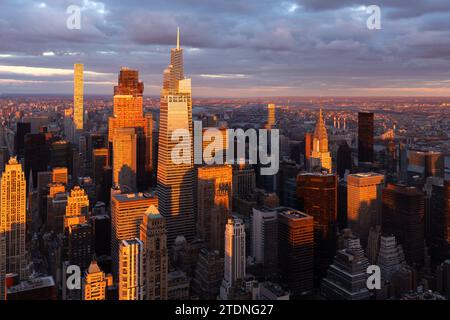 Blick auf die Wolkenkratzer von Midtown Manhattan aus der Vogelperspektive von New York City, beleuchtet durch warmes Licht mit langen Schatten Stockfoto