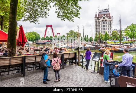 Touristen genießen die Straßencafés und den Blick über den Alten Hafen von Rotterdam mit Flussbooten, das historische Gebäude Witte Huis und die Willemsbrug. Stockfoto