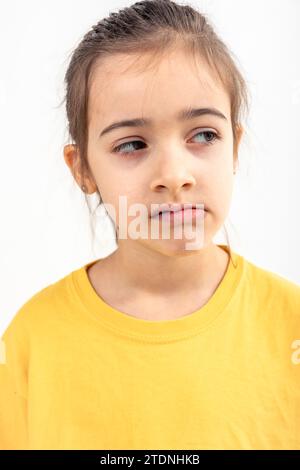 Das kleine kaukasische Mädchen sieht unzufrieden aus auf weißem Hintergrund isoliert. Stockfoto