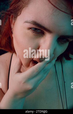 Vertikales künstlerisches Porträt für soziale Netzwerke, von großer Größe junge Latina Frau mit rotem Haar und weißem Haar, mit natürlichem Make-up, posiert sie Looki Stockfoto