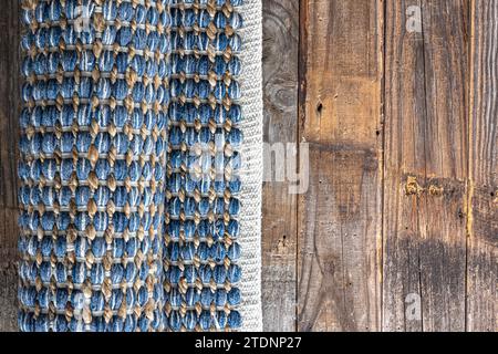 Handgewebter Teppich mit geometrischem Denim-Bereich auf Holzboden. Stockfoto