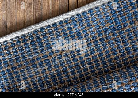 Handgewebter Teppich mit geometrischem Denim-Bereich auf Holzboden. Stockfoto