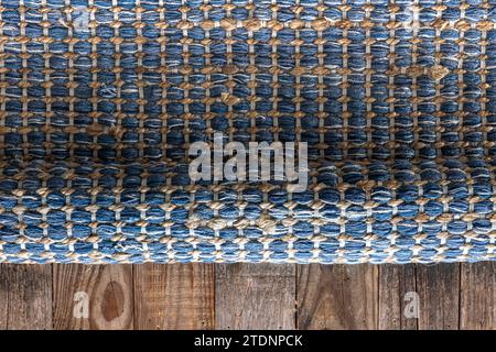Handgewebter Teppich mit geometrischem Denim-Bereich auf Holzboden. Stockfoto