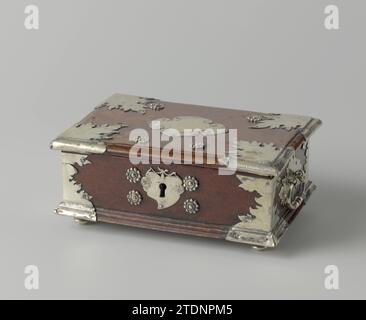 Sirihkist von Amboina -Wortelhout mit Silber, anonymer Teig, 1700 - 1799 Sirihkist, rechteckig, aus Amboina-Wurzelholz mit Beschlagnahme von Silber. Der Sarg hat einen klappbaren Deckel; Deckel und Boden haben eine profilierte Kante. Innen rot lackiert. Auf silbernen Beinen. Beschläge in flammenförmiger Blattform an den Ecken des Deckels und der Wände sowie als Rückplatten der Griffe an den Seiten. Die Schließplatte in Form einer Betel- oder Pinangnut, eine Kartusche in der Mitte des Deckels. Vier Rosetten um die Schließplatte sowie auf dem Deckel. Schlüssel aus Silber mit Halt in Form eines Herzens zwischen zwei Nagas. Die Stockfoto