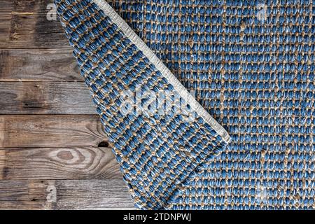 Handgewebter Teppich mit geometrischem Denim-Bereich, geflochtene Jute-Hintergrundstruktur. Stockfoto