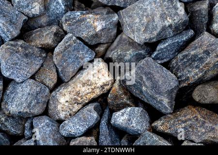 Graue große Kiessteine. Hintergrund mit Granitgestein mit selektivem Fokus. Konzept der Bauindustrie. Stockfoto