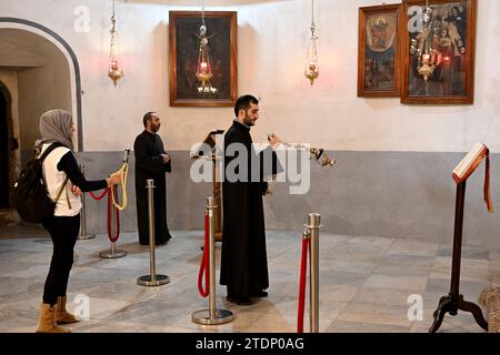 Bethlehem, Westjordanland. Dezember 2023. Armenier beten in der Geburtskirche, die vermutlich der Ort der Geburt Jesu ist, in der biblischen Stadt Bethlehem, Westjordanland, am Montag, den 18. Dezember 2023. Die Kirche, die normalerweise mit Touristen gefüllt ist, ist seit dem 8. Oktober leer, dem Tag, nachdem die Hamas Israel angegriffen hatte und der Krieg im Gazastreifen begann. Christliche Führer haben die Errichtung des Weihnachtsbaums auf dem Managerplatz, fröhliche Straßendekorationen und Feierlichkeiten in Solidarität mit den Palästinensern in Gaza abgesagt. Foto: Debbie Hill/ Credit: UPI/Alamy Live News Stockfoto