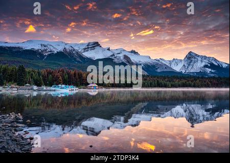 Wunderschöner Blick auf die Rocky Mountains mit farbenfrohem Himmel und Fähre am Pier im Maligne Lake im Jasper Nationalpark, Alberta, Kanada Stockfoto