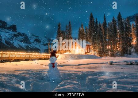 Winterwunderland von Emerald Lake mit Holzhütte und Schneemann mit weihnachtsmütze im fallenden Schnee im Yoho Nationalpark, British Columbia, Kanada Stockfoto