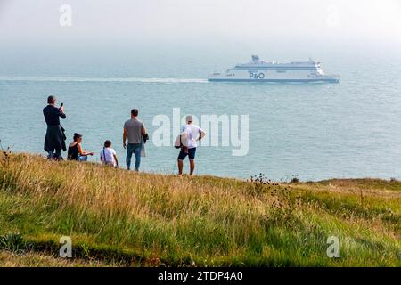 Eine Gruppe von Leuten, die eine P&O-Autofähre von den White Cliffs of Dover an der Küste von Kent im Südosten Englands, Großbritannien, beobachten. Stockfoto