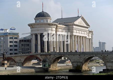 Das Archäologische Museum von Mazedonien im Hintergrund mit der Steinbrücke von Skopje im Vordergrund, die über den Fluss Vardar führt. Stockfoto