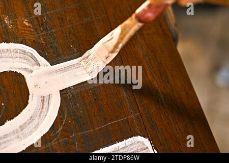 Lackierte Holzoberfläche mit Pinsel und weißer Farbe. Natürliche Holzstruktur. Stockfoto