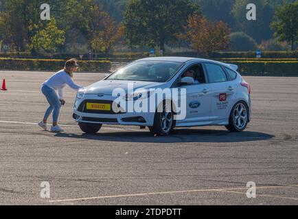 Stuntfahrer Paul Swift fährt seinen Ford Focus auf zwei Rädern und Mustang dreht sich Stockfoto