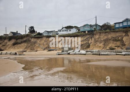 November 2023. Stranderosion bei Hemsby in Norfolk, wobei große Straßenabschnitte auf den Marrams nach den jüngsten Stürmen verloren gingen. Das freiliegende Wasser und die Stromleitungen machen den Zugang zum Strand gefährlich und fünf Bungalows wurden zum Abriss verurteilt. Mit jedem Sturm und jeder Gezeitenflut nähert sich ein größeres Wohngebiet aus teureren Ziegelsteinen und Mörserhäusern dem Rand. Weitere Maßnahmen zur Seeverteidigung zur Erweiterung eines bestehenden Felsbergs werden jetzt nicht mehr stattfinden, da Hemsby „nicht für staatliche Mittel qualifiziert“ ist. Stockfoto