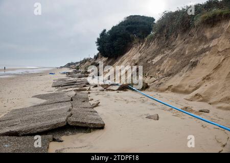 November 2023. Stranderosion bei Hemsby in Norfolk, wobei große Straßenabschnitte auf den Marrams nach den jüngsten Stürmen verloren gingen. Das freiliegende Wasser und die Stromleitungen machen den Zugang zum Strand gefährlich und fünf Bungalows wurden zum Abriss verurteilt. Mit jedem Sturm und jeder Gezeitenflut nähert sich ein größeres Wohngebiet aus teureren Ziegelsteinen und Mörserhäusern dem Rand. Weitere Maßnahmen zur Seeverteidigung zur Erweiterung eines bestehenden Felsbergs werden jetzt nicht mehr stattfinden, da Hemsby „nicht für staatliche Mittel qualifiziert“ ist. Stockfoto