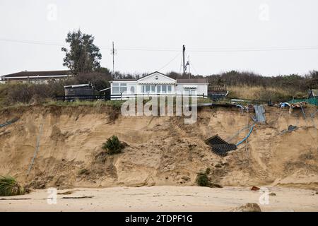 November 2023. Stranderosion bei Hemsby in Norfolk, wobei große Straßenabschnitte auf den Marrams nach den jüngsten Stürmen verloren gingen. Das freiliegende Wasser und die Stromleitungen machen den Zugang zum Strand gefährlich und fünf Bungalows wurden zum Abriss verurteilt. Mit jedem Sturm und jeder Gezeitenflut nähert sich ein größeres Wohngebiet aus teureren Ziegelsteinen und Mörserhäusern dem Rand. Weitere Maßnahmen zur Seeverteidigung zur Erweiterung eines bestehenden Felsbergs werden jetzt nicht mehr stattfinden, da Hemsby „nicht für staatliche Mittel qualifiziert“ ist. Stockfoto