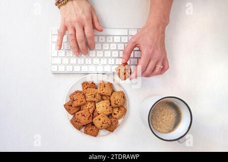 Kaffeepause mit Keksen während der Arbeit am Computer oder in der Freizeit Stockfoto