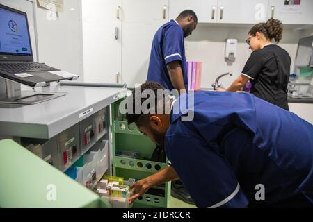 Krankenschwester Evans Sarbeng im Behandlungsraum mit Klinikleitung Dani Botelho und Mitschwester John Haizel Cobbinah. Sowohl Evans als auch John sind Krankenschwestern aus Ghana, während Dani aus Portugal kommt. St. Cecilias Pflegeheim Scarborough. Stockfoto