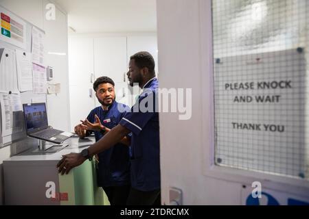 Krankenschwester Evans Sarbeng im Behandlungsraum mit Mitschwester John Haizel Cobbinah. Sowohl Evans als auch John sind Krankenschwestern aus Ghana, während Dani aus Portugal kommt. St. Cecilias Pflegeheim Scarborough. Stockfoto