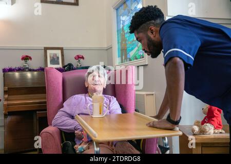 Krankenschwester Evans Sorbeng (aus Ghana) mit Assistenzin Angela Morgan (76) im Tageszimmer des St. Cecilias Nursing Home Scarborough St. Cecilias Nursing Home Scarborough. Stockfoto