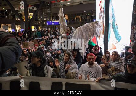 Berlin, Deutschland. Dezember 2023. Am 19. Dezember 2023 fand am Berliner Hauptbahnhof eine pro-palästinensische Demonstration statt. Dieses Ereignis, das von zivilem Ungehorsam geprägt war, zog Hunderte dazu an, ihre Ablehnung gegen Israels militärische Aktionen gegen die Hamas zu äußern. Die Teilnehmer skandierten energisch Slogans wie „Freies Palästina“ und „Israel Bombs, Germany finances“, während sie palästinensische Flaggen und Keffiyehs schleuderten. Trotz ihres nicht registrierten Status und der Handlungen zivilen Ungehorsams verlief die Demonstration ohne Intervention der Polizei. (Bild: © Michael Kuenne/PRESSCOV Via ZUMA Stockfoto