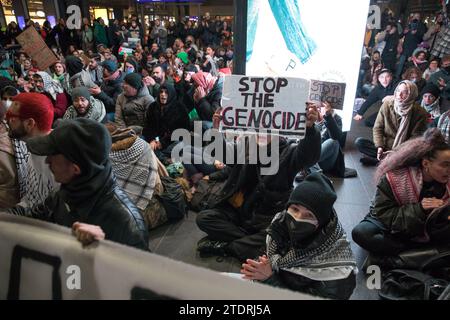 Berlin, Deutschland. Dezember 2023. Am 19. Dezember 2023 fand am Berliner Hauptbahnhof eine pro-palästinensische Demonstration statt. Dieses Ereignis, das von zivilem Ungehorsam geprägt war, zog Hunderte dazu an, ihre Ablehnung gegen Israels militärische Aktionen gegen die Hamas zu äußern. Die Teilnehmer skandierten energisch Slogans wie „Freies Palästina“ und „Israel Bombs, Germany finances“, während sie palästinensische Flaggen und Keffiyehs schleuderten. Trotz ihres nicht registrierten Status und der Handlungen zivilen Ungehorsams verlief die Demonstration ohne Intervention der Polizei. (Bild: © Michael Kuenne/PRESSCOV Via ZUMA Stockfoto