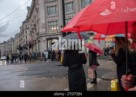 Weihnachtseinkäufer profitieren von den frühfestlichen Verkäufen am Oxford Circus im Londoner West End an einem nassen Wintertag in England, Großbritannien Stockfoto