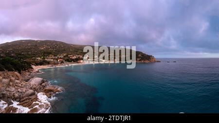 Ein Blick auf den Cavoli Beach auf der Insel Elba kurz nach Sonnenuntergang mit einem nebligen lila Himmel Stockfoto