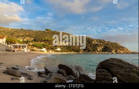 Ein Blick auf den Strand von Cavoli auf Elba im warmen Abendlicht und Felsbrocken im Vordergrund Stockfoto