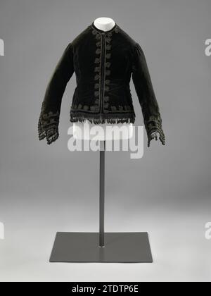 Kindermantel, anonym, ca. 1870 Kinderjacke aus schwarzem Seitengelb, gefüttert mit einem gepolsterten und genähten schwarzen Satin-Stoff und mit schwarzem Soutache verziert. Modell: Hüfte und Schwanz. Rundhalsausschnitt, lange, weite Ärmel. In der Mitte des Rückens eine vertikale Naht, die in einem Spalt endet. Verschluss in der Mitte vorn durch Metallhaken und -Ösen. Das Futter ist in einem Waffelmuster genäht; an den vorderen Gebäuden mit großen Flächen, kleinere an den hinteren Grundstücken. Seitliche Trennungen. Dekoration: Entlang des Nackens, der Vorder- und Rückenpartie, die Ärmel und der Saum sind mit schwarzem Blattmuster so verziert Stockfoto