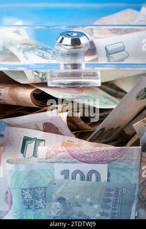 Wohltätigkeits- und Geldscheine in einer transparenten Spendenbox für Geldspenden. Eine finanzielle Unterstützung, sammelt Geld. Der Akt des Gebens unterstützt Charitab Stockfoto