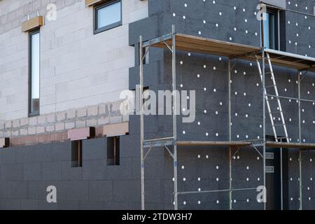 Neubau des Hausgebäudes in der Prozessdämmung der Hauswand mit Schichten moderner Wärmedämmstoffe. Außenverkleidung in Konstrukten Stockfoto