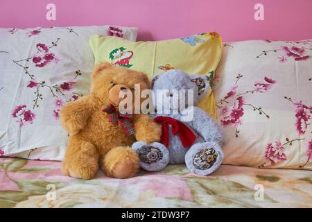 Zwei Teddybären sitzen auf dem Bett Stockfoto